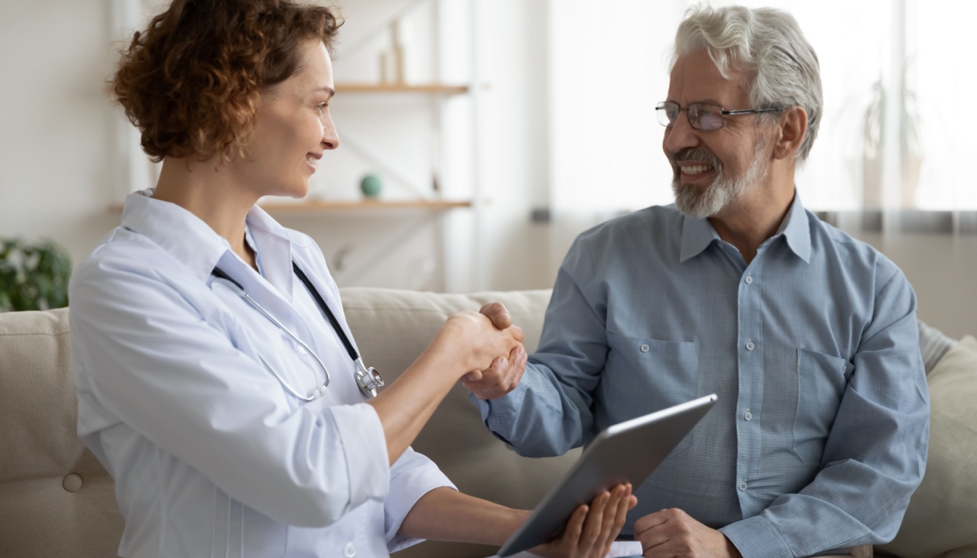 Patient shaking doctor's hand, who is holding a tablet; provider engagement concept